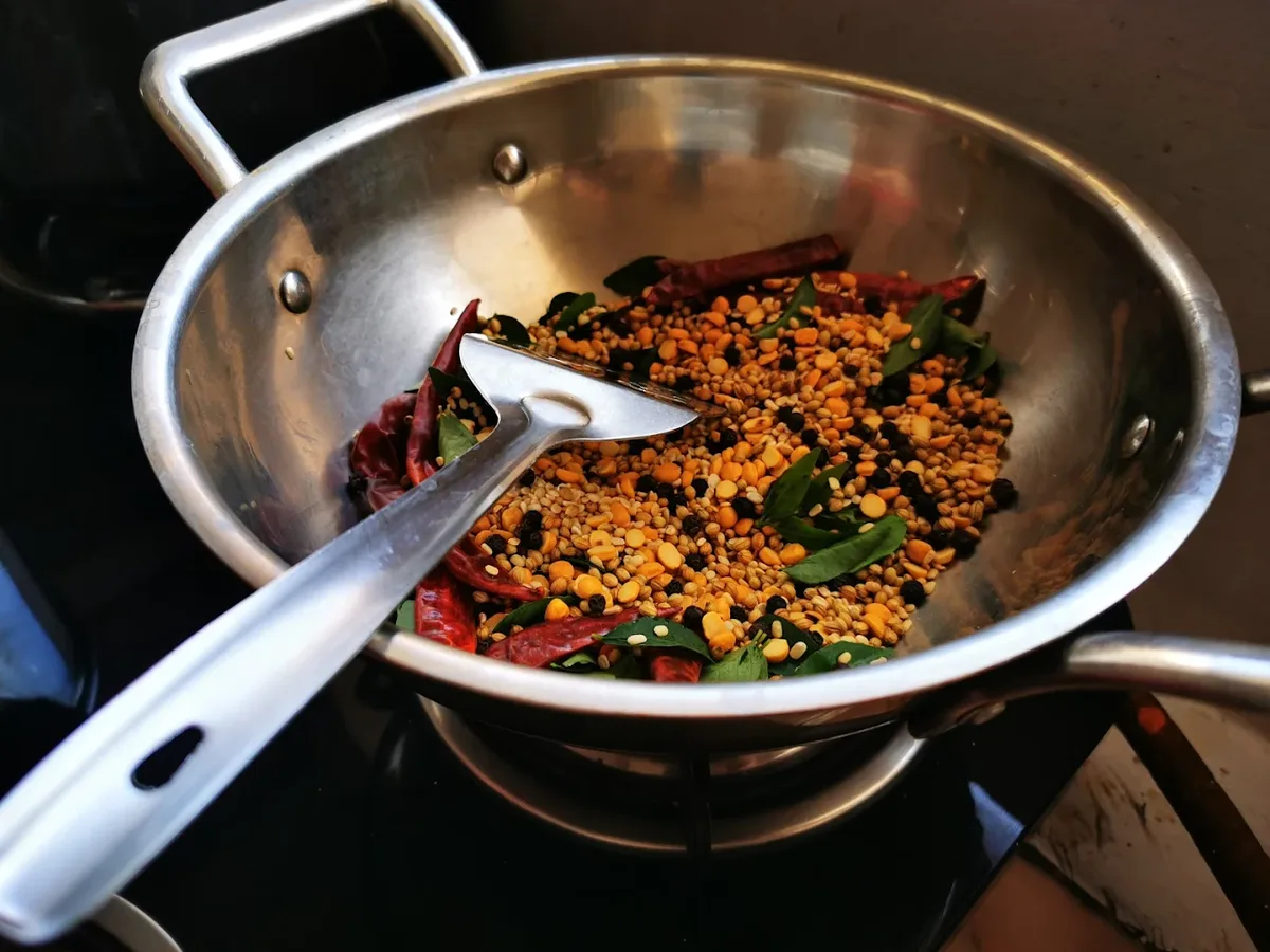 Curry leaves tempering in South Indian cooking class Rishikesh